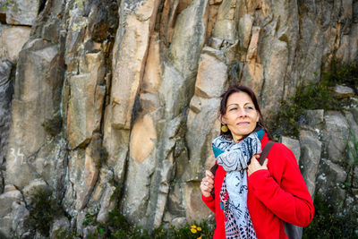 Portrait of a smiling young woman standing on rock