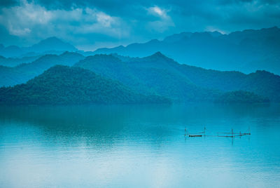 Scenic view of lake by mountains against sky