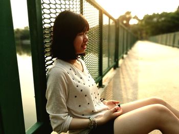 Woman sitting on bridge