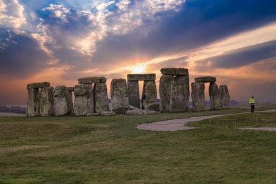 Built structure on landscape against sky during sunset