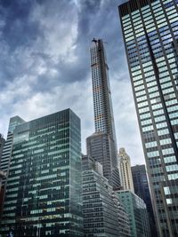 Low angle view of modern building against cloudy sky