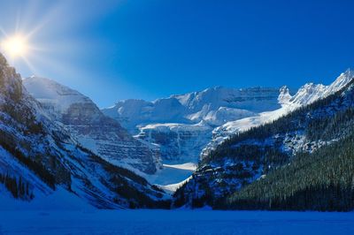 Scenic view of snowcapped mountains against clear blue sky