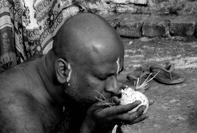 Close-up of man smelling flower outdoors