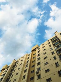 Low angle view of buildings against cloudy sky