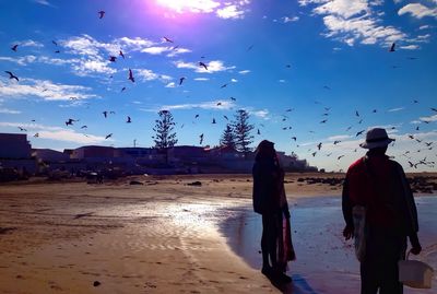 People on beach against sky