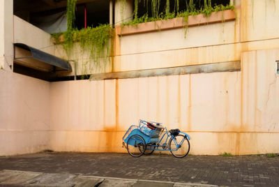 Bicycle parked against wall of building