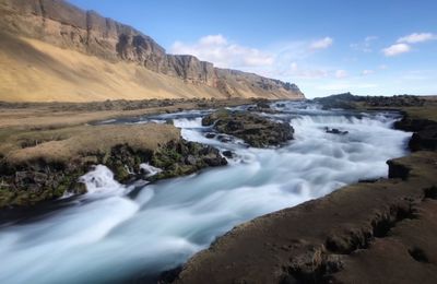 Scenic view of waterfall against sky