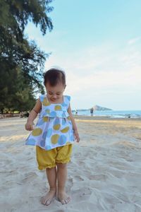 Full length of girl standing on sand at beach