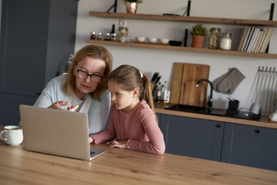 Grandmother and granddaughter talking on video call at home