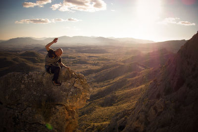 Full length of man climbing on mountain against sky