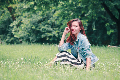 Portrait of young woman sitting on field