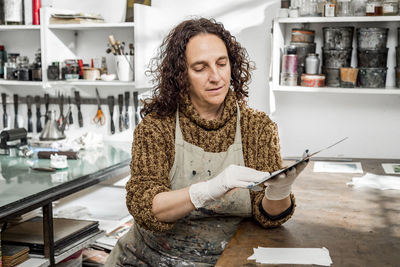 Female artist preparing a plate for an art print.