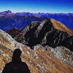 Rear view of man on rock against sky