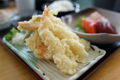 Close-up of tempura shrimp in plate on wooden table