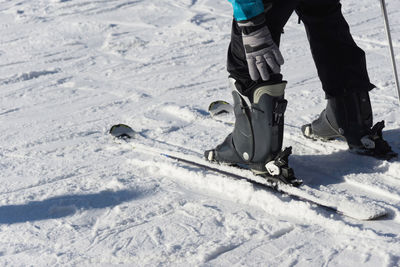 Low section of person walking on snow covered landscape