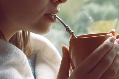 Midsection of woman having drink