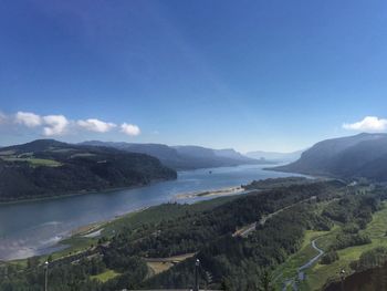 Scenic view of sea and mountains against blue sky