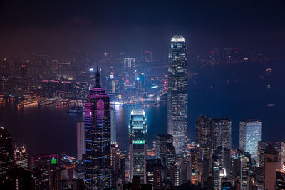 Illuminated cityscape against sky at night