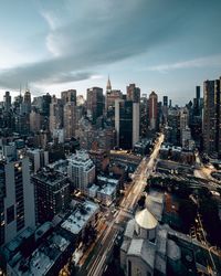 Aerial view of modern buildings in city against sky during sunset