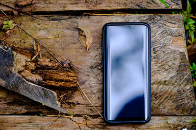 High angle view of smart phone on wooden table