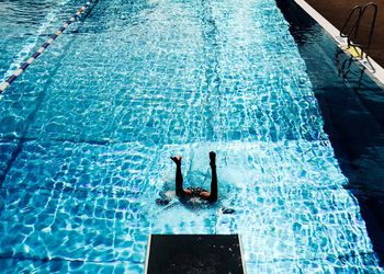 Low section of man jumping in swimming pool