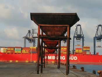 Red pier at construction site against sky