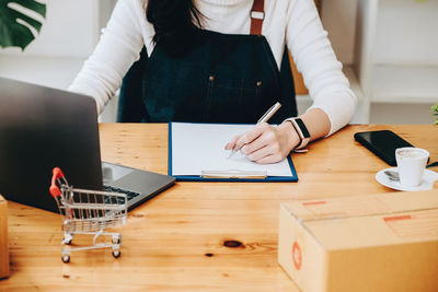 Midsection of woman working at table