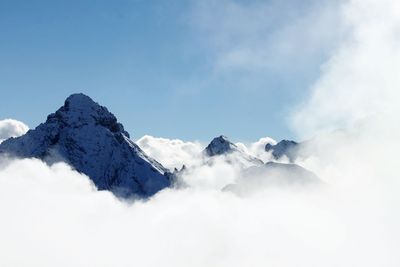 Low angle view of snowcapped mountains against sky