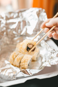 Japanese food delivery service rolls in plastic box and foil, hot and baked rolls, food delivery