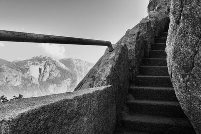 Scenic view of mountains against sky seen through railing at stone staircase