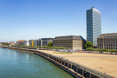 River in city against clear blue sky