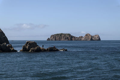 Scenic view of rocks in sea against sky