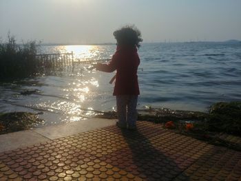Full length of boy standing on footpath against sky