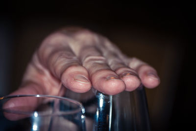 Cropped image of hand covering glass