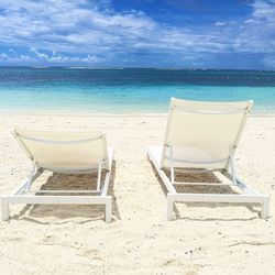 Chairs on beach against sky