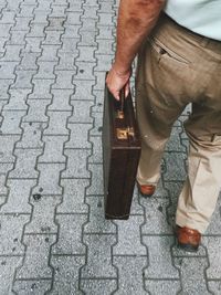 Low section of man standing on cobblestone