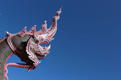 Low angle view of statue against blue sky