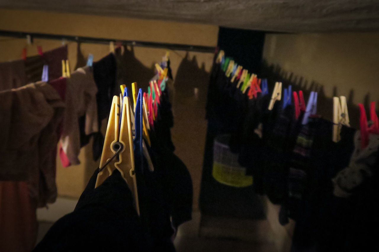 CLOSE-UP OF MULTI COLORED CLOTHES HANGING ON WALL