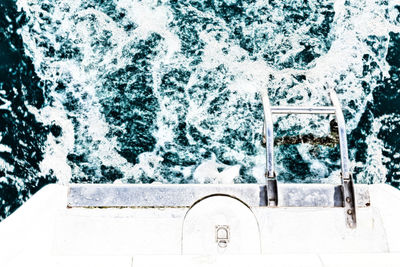 High angle view of railing against sea during winter