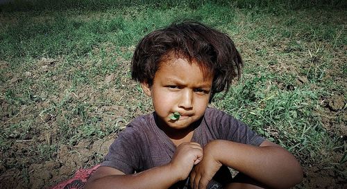 Portrait of young man sitting on field