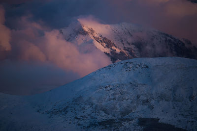 Scenic view of snowcapped mountains against sky during sunset