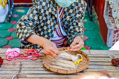 Midsection of man working on barbecue grill