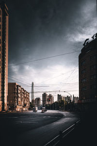 City street and buildings against sky at dusk