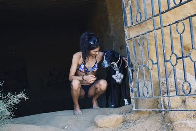 Young woman with dog by gate