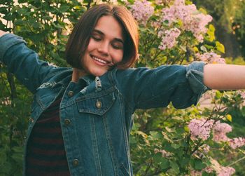 Close-up of smiling young woman with plants