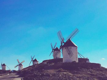 Low angle view of traditional windmill against clear blue sky