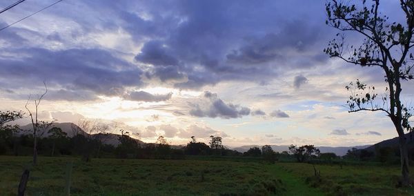 Panoramic shot of field against sky during sunset