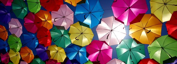 Low angle view of multi colored umbrellas hanging