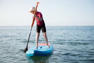 Man standing in sea against clear sky