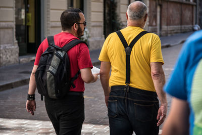Rear view of men walking in city